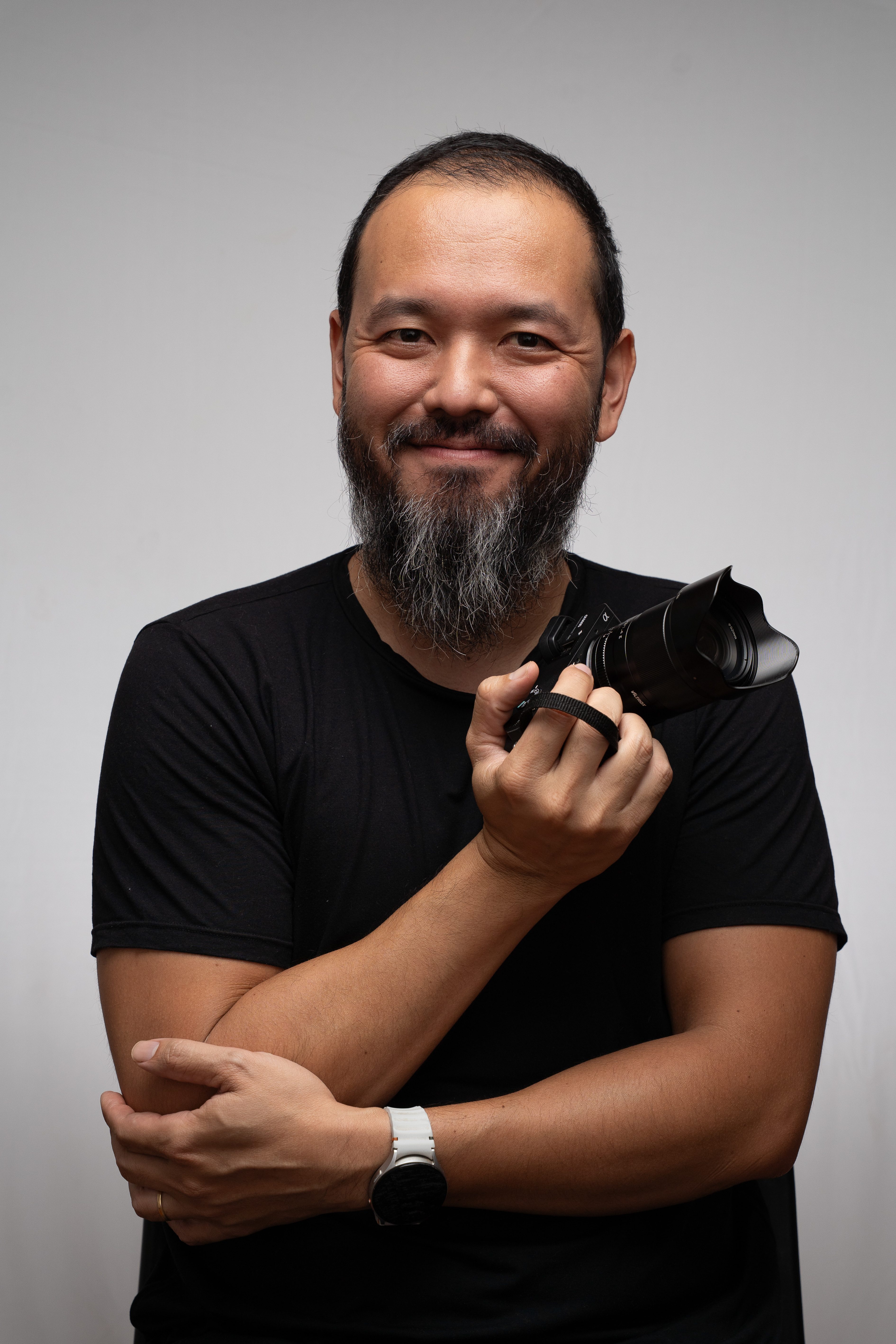 Retrato do fotógrafo da Tavalá Fotografia segurando sua câmera